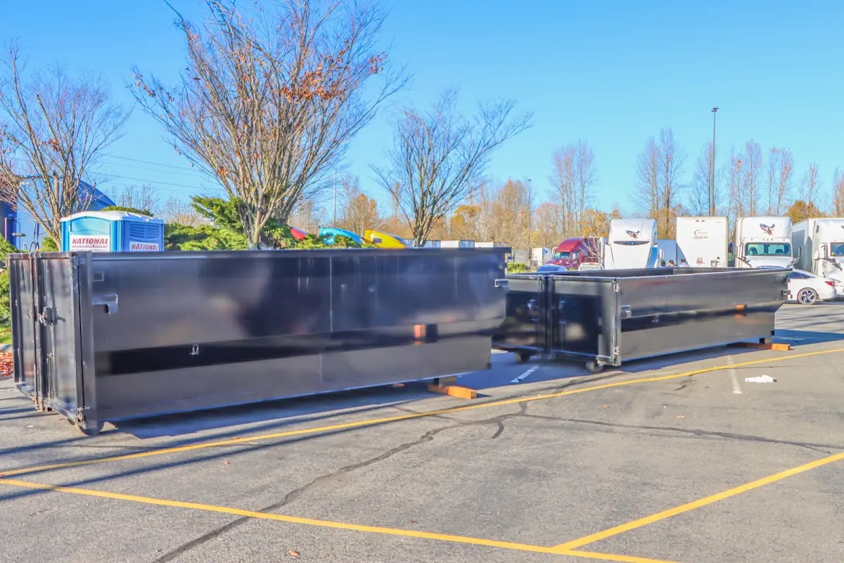 Professional dumpster rental service with roll-off container on residential driveway in Dennis